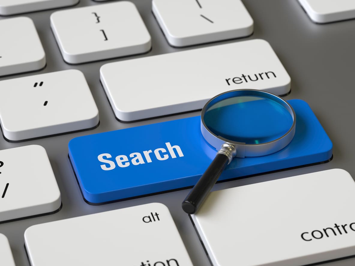 a magnifying glass sitting on top of a keyboard.