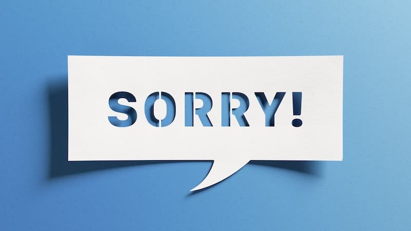 A white speech bubble against an online blue background contains the word "SORRY!" in bold, capital letters. The text is cut out, revealing the same blue background through the letters.