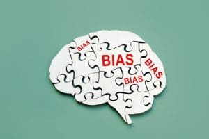 Puzzle pieces forming a brain shape are labeled with the word "BIAS" in red text on a green background.