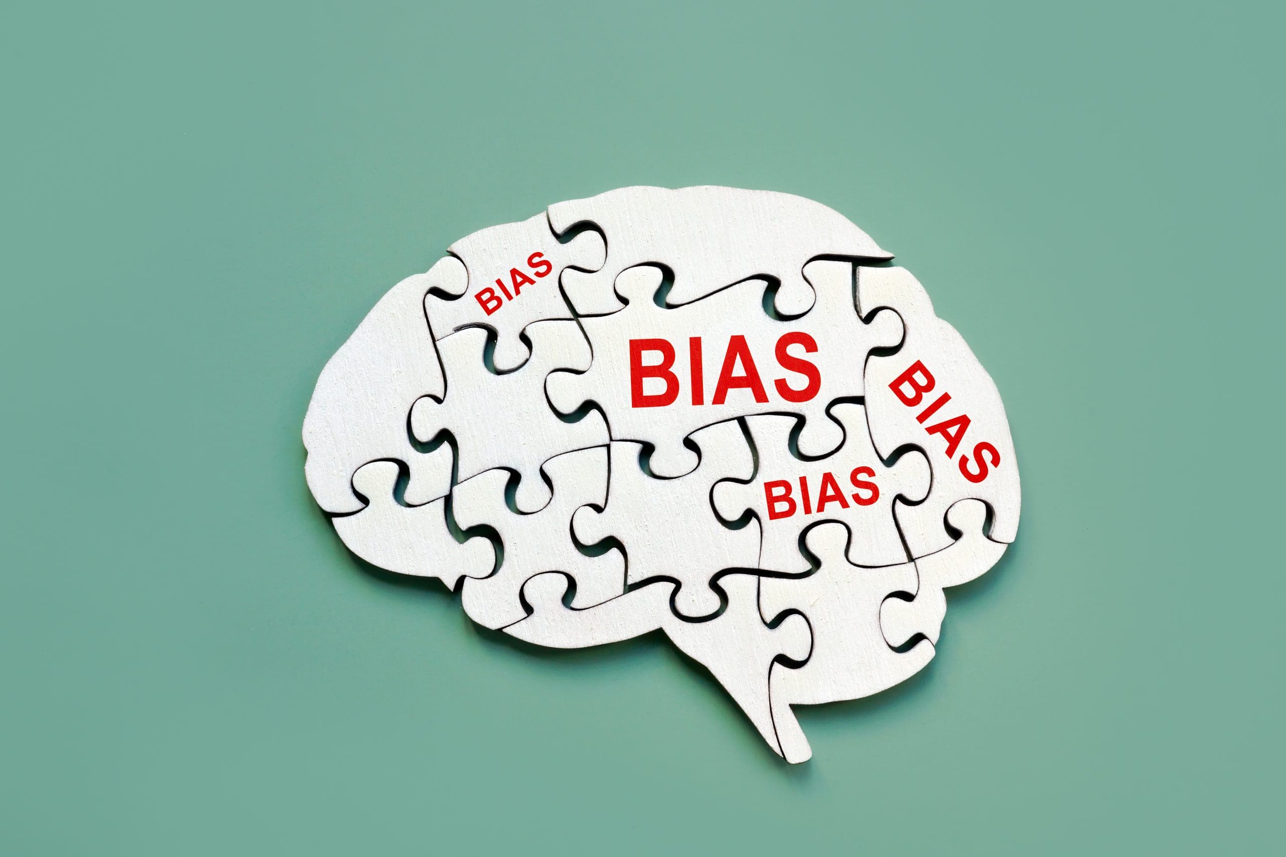 Puzzle pieces forming a brain shape are labeled with the word "BIAS" in red text on a green background.