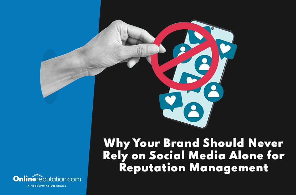 A black-and-white image shows a hand gripping a smartphone with social media icons, overshadowed by a red prohibition symbol. The text advises, "Why Your Brand Should Never Rely on Social Media Alone for Reputation Management," highlighting the pitfalls of limiting reputation management strategies.