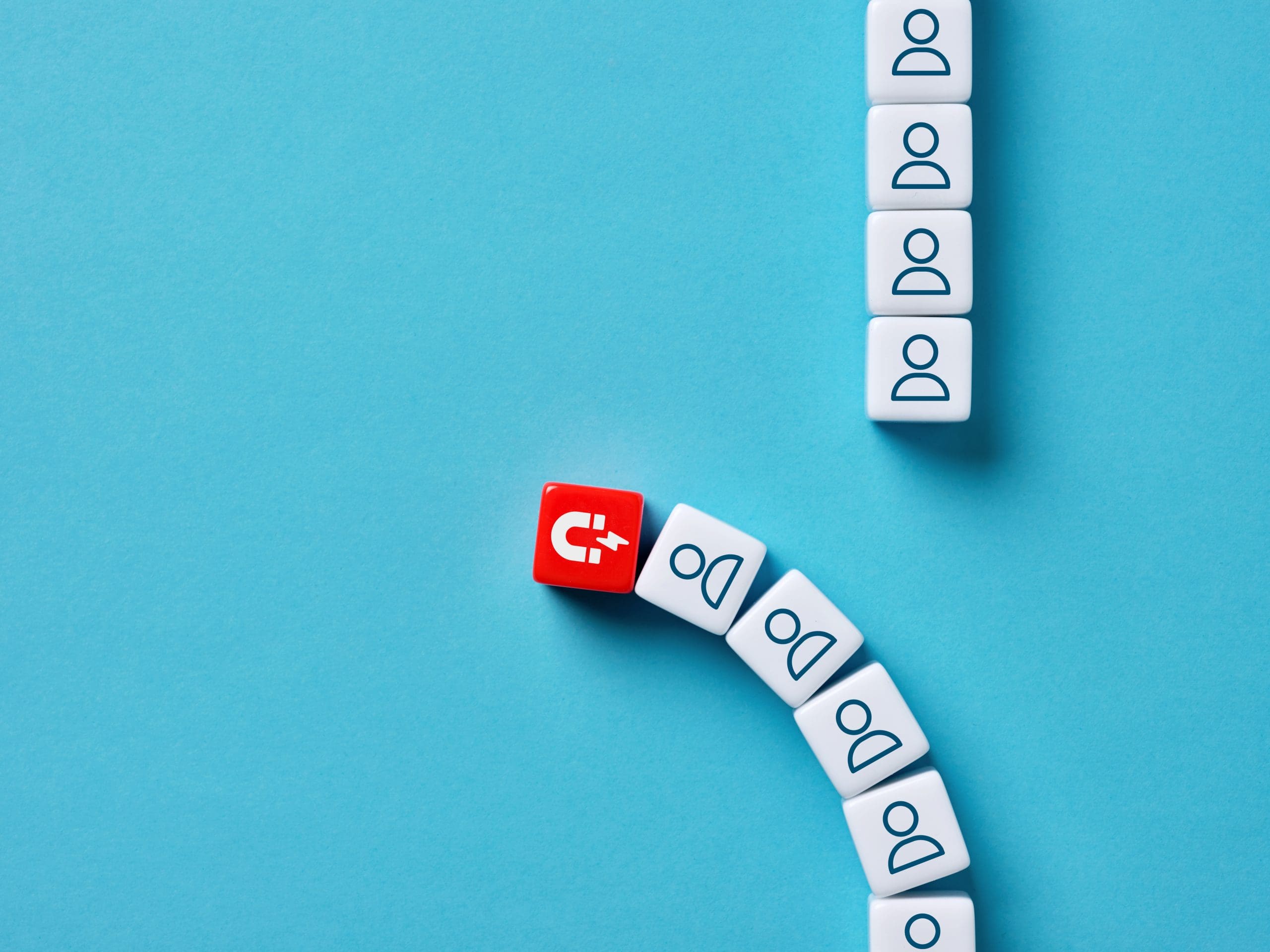 A curved line of white cubes with "Do" on them, and one red cube with a magnet symbol, are arranged against a blue background. The cubes form a path, turning around the magnet cube.